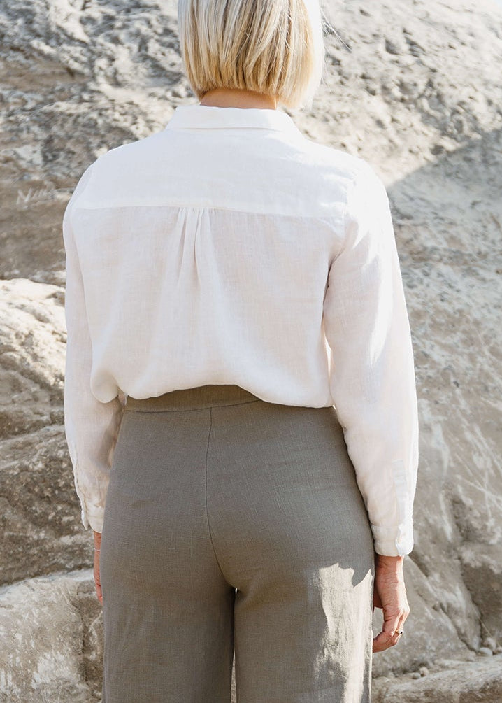 back view of woman wearing a linen white button up shirt.